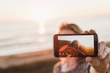 Selfie eines lächelnden Teenagers auf dem Display eines Smartphones - UUF08809