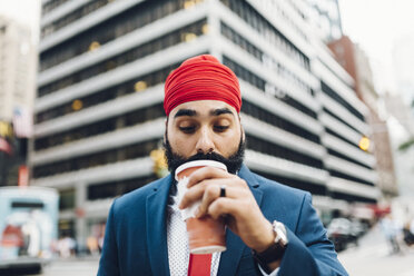Indischer Geschäftsmann, der in Manhattan spazieren geht und Kaffee trinkt - GIOF01553