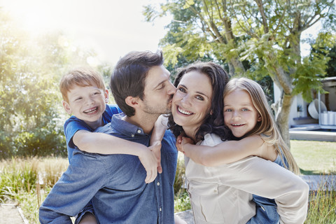 Porträt einer glücklichen Familie im Garten, lizenzfreies Stockfoto