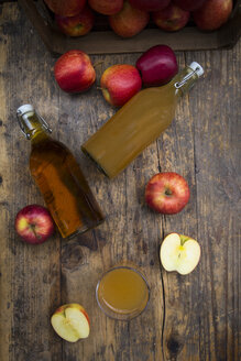 Flasche und Glas mit Apfelsaft, trüb und klar, rote Äpfel auf Holz - LVF05442