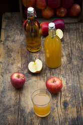 Flasche und Glas mit Apfelsaft, trüb und klar, rote Äpfel auf Holz - LVF05446