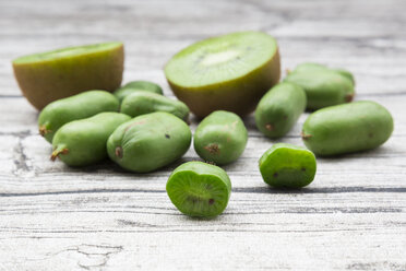 Sliced and whole kiwis and two halves of a kiwi on wood - LVF05456