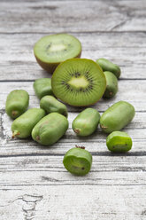 Sliced and whole kiwi and hardy kiwis on wood - LVF05457