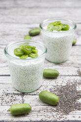 Two glasses of natural yoghurt with chia seeds and slices of hardy kiwis - LVF05460