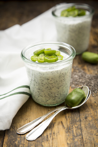 Zwei Gläser Naturjoghurt mit Chiasamen und Scheiben von winterharten Kiwis, lizenzfreies Stockfoto