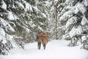Glückliches Paar beim Spaziergang im Winterwald - HHF05444