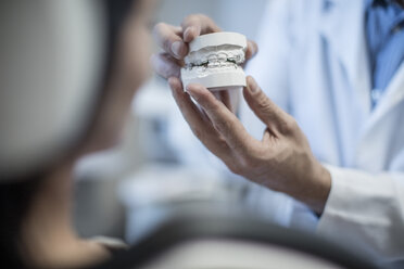Orthodontist showing patient dental mold - ZEF10605