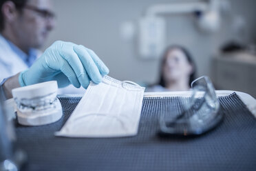 Dentist preparing for treatment taking mask - ZEF10612