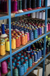 Multicolored cotton reels on shelf - ZEF10696