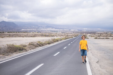 Spanien, Teneriffa, Junge geht auf leerer Landstraße - SIPF00943