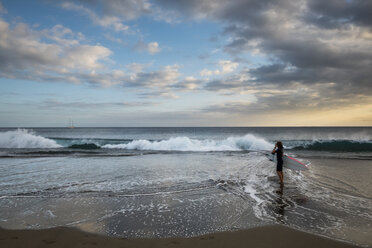 Spanien, Teneriffa, Junge mit Surfbrett am Strand bei Sonnenuntergang - SIPF00956