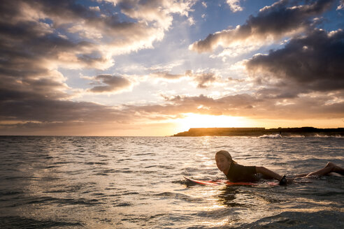 Spanien, Teneriffa, Junge beim Surfen im Meer bei Sonnenuntergang - SIPF00962