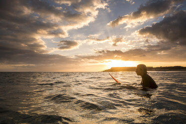 Spanien, Teneriffa, Junge beim Surfen im Meer bei Sonnenuntergang - SIPF00963