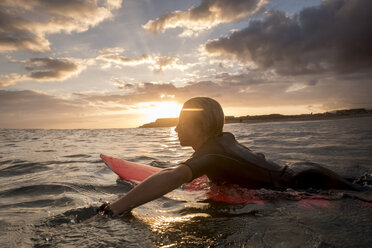 Spain, Tenerife, boy surfing in the sea at sunset - SIPF00964