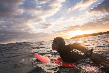 Spain, Tenerife, boy surfing in the sea at sunset - SIPF00965
