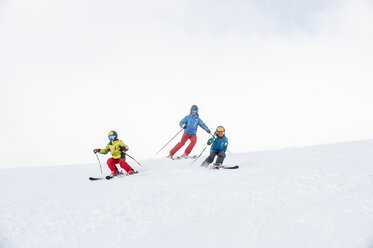 Father and two sons skiing together - HHF05451