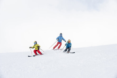 Vater und zwei Söhne fahren gemeinsam Ski - HHF05451