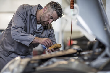 Automechaniker in einer Werkstatt mit Diagnosegeräten - ZEF10705