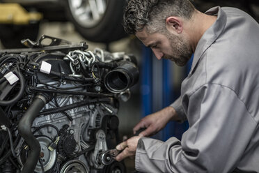 Automechaniker in einer Werkstatt bei der Reparatur eines Motors - ZEF10719