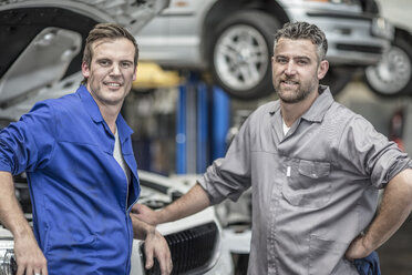 Two confident car mechanics in repair garage - ZEF10727