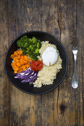 Lunch bowl of quinoa, red cabbage, carrots, roasted chickpeas, broccoli, poached egg and ajvar - LVF05479