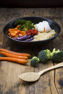 Lunch bowl of quinoa, red cabbage, carrots, roasted chickpeas, broccoli, poached egg and ajvar - LVF05483