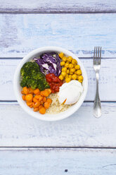 Lunch bowl of quinoa, red cabbage, carrots, roasted chickpeas, broccoli, poached egg and ajvar - LVF05484