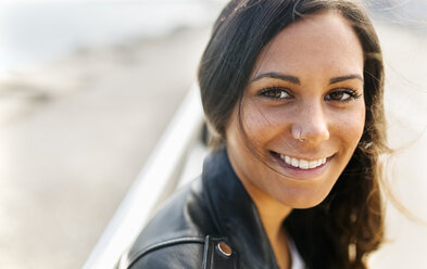 Portrait of smiling young woman with freckles and nose piercing - MGOF02523