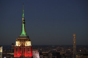 USA, New York City, Stadtbild mit Spitze des beleuchteten Empire State Building am Abend - BCDF00226