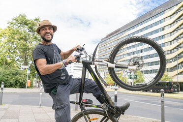 Porträt eines lächelnden Mannes mit Fahrrad - TAMF00698