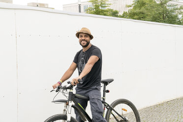 Porträt eines lächelnden Mannes auf einem Fahrrad - TAMF00699