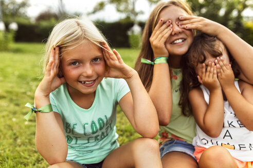 Drei Mädchen haben Spaß zusammen auf einer Wiese - MGOF02543