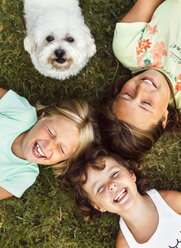 Three happy girls and a puppy on a meadow - MGOF02547