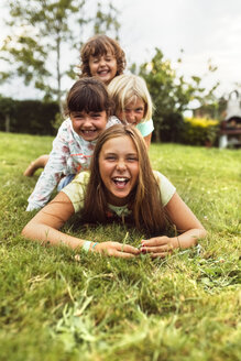 Vier Mädchen, die gemeinsam auf einer Wiese Spaß haben - MGOF02548