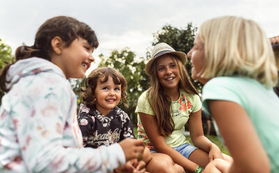 Four girls talking together on a meadow - MGOF02551