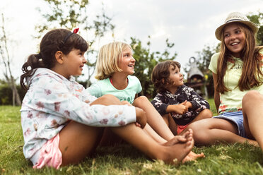 Four girls talking together on a meadow - MGOF02554