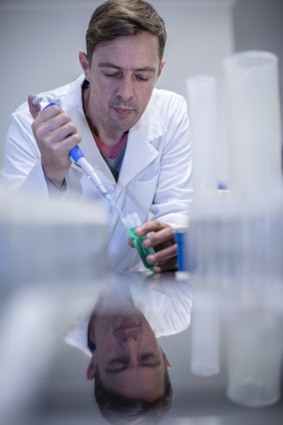 Wissenschaftler beim Pipettieren im Labor, lizenzfreies Stockfoto