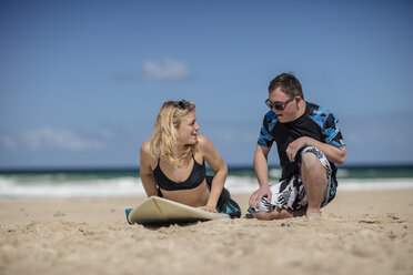 Teenage boy with down syndrome having surf lessons on beach - ZEF10869