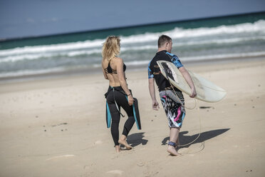Jugendlicher mit Down-Syndrom und Frau mit Surfbrett am Strand - ZEF10872