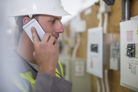 Elektriker im Gespräch am Telefon, lizenzfreies Stockfoto