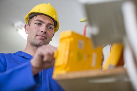 Elektriker bei der Arbeit mit einem Voltmeter, lizenzfreies Stockfoto