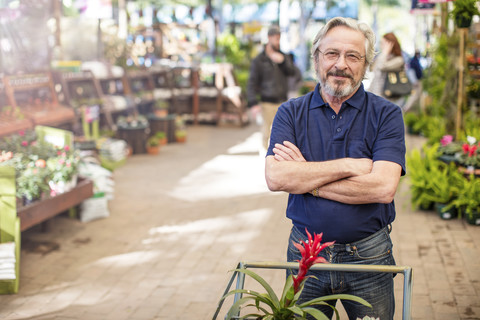 Älterer Mann kauft in einem Gartencenter Pflanzen ein, lizenzfreies Stockfoto