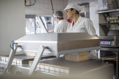 Käsereiarbeiter beim Verpacken von Käse, lizenzfreies Stockfoto
