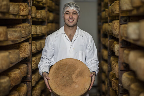 Käsereiarbeiter hält stolz einen Laib Käse - ZEF11060