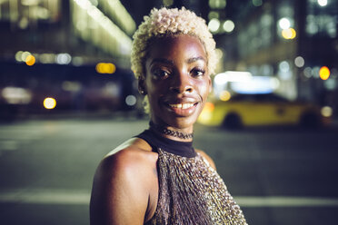 USA, New York City, Porträt einer glücklichen jungen Frau auf dem Times Square bei Nacht - GIOF01564