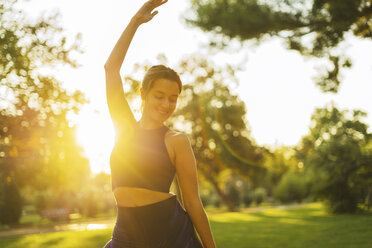 Sportliche junge Frau im Park bei Sonnenuntergang - EBSF01817