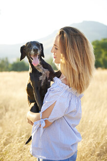 Happy woman with her dog in nature - JCF00058