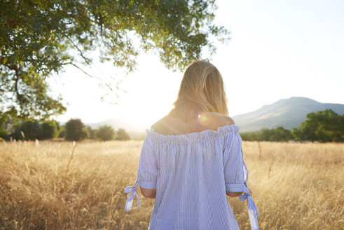 Back view of blond woman in nature - JCF00060