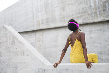 Back view of woman listening music with pink headphones - SIPF00974