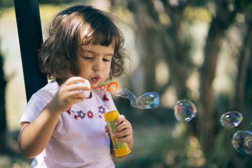 Little girl blowing soap bubbles - LOMF00426